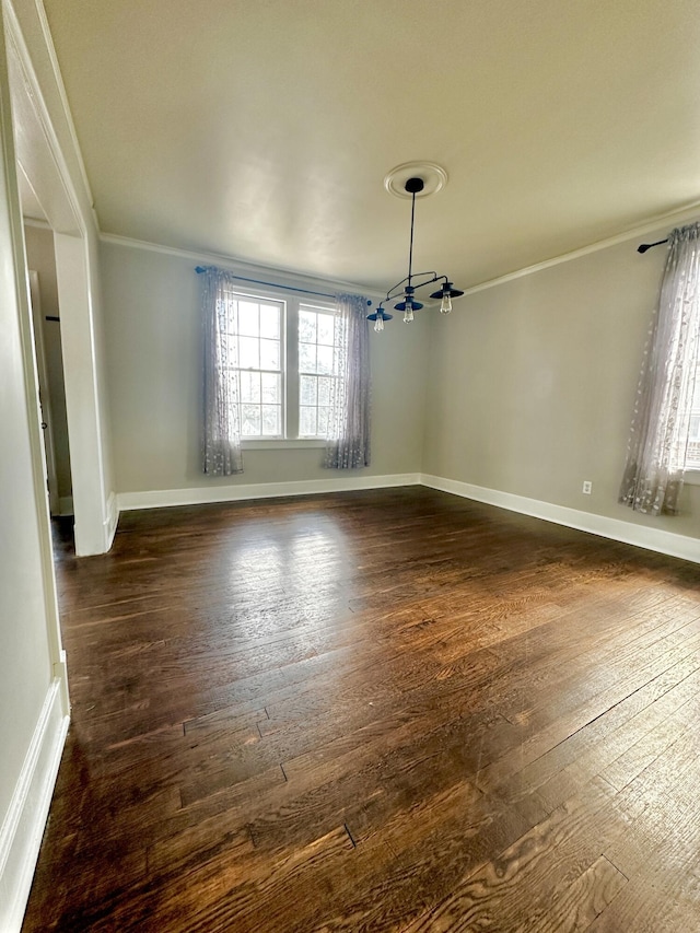 unfurnished dining area with baseboards, dark wood finished floors, and crown molding