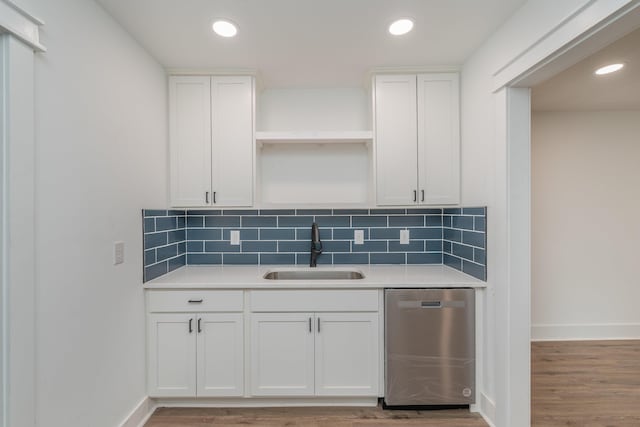 kitchen with dishwasher, decorative backsplash, white cabinets, and sink