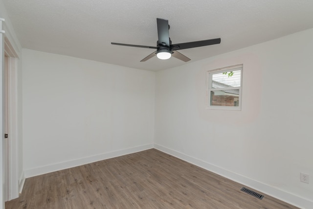 spare room featuring a textured ceiling, hardwood / wood-style flooring, and ceiling fan