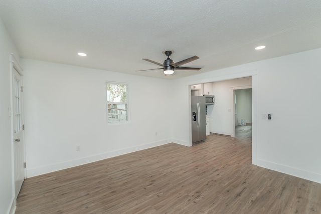 unfurnished room with ceiling fan, a textured ceiling, and hardwood / wood-style flooring