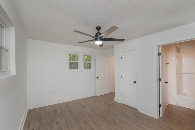 unfurnished bedroom featuring ceiling fan, a textured ceiling, and light wood-type flooring