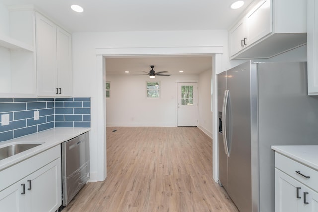 kitchen featuring white cabinetry, ceiling fan, stainless steel appliances, backsplash, and light hardwood / wood-style floors