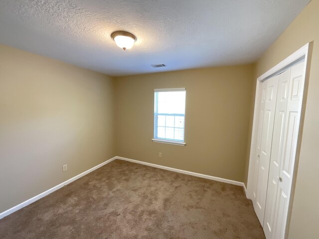 930 Hunting Horn Way, Evans, GA 30809 - unfurnished bedroom featuring a closet, carpet floors, baseboards, and a textured ceiling
