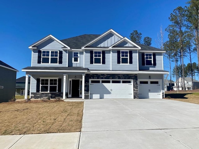 323 Granard St, Grovetown, GA 30813 - craftsman house with a garage, concrete driveway, stone siding, covered porch, and a front lawn