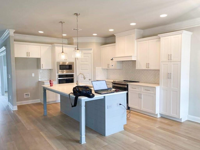 323 Granard St, Grovetown, GA 30813 - kitchen with appliances with stainless steel finishes, tasteful backsplash, white cabinetry, ornamental molding, and a kitchen island with sink