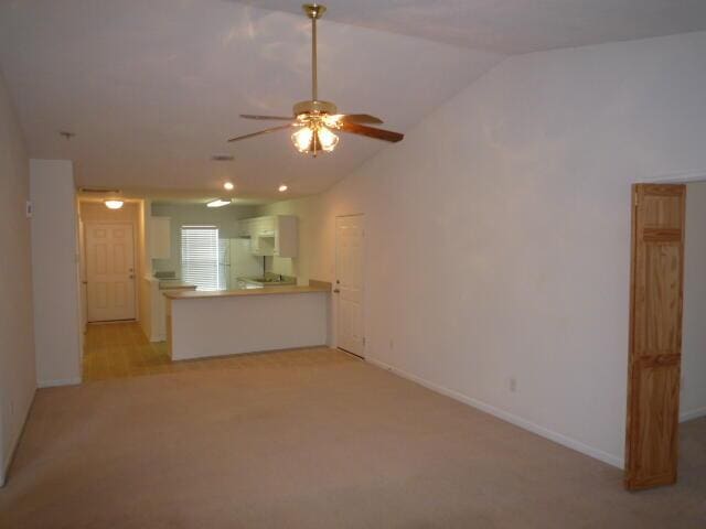7423 Exuma Dr, Augusta, GA 30909 - unfurnished living room with vaulted ceiling, ceiling fan, light colored carpet, and baseboards