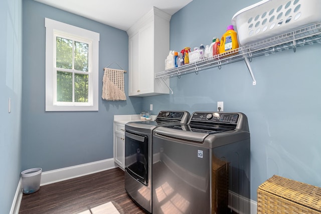clothes washing area featuring washing machine and clothes dryer, baseboards, cabinet space, and dark wood-style floors