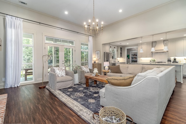 living area with ornamental molding, visible vents, a chandelier, dark wood-style flooring, and plenty of natural light