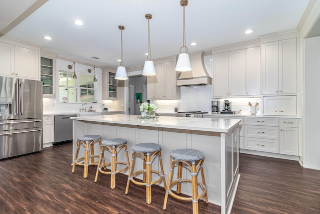 kitchen featuring stainless steel appliances, glass insert cabinets, dark wood-type flooring, and custom range hood