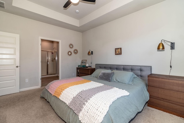 bedroom with ceiling fan, light colored carpet, baseboards, a tray ceiling, and visible vents