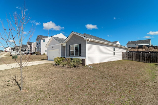 view of home's exterior with a lawn, a garage, fence, and driveway