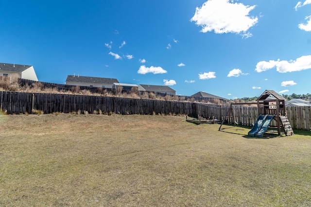 view of yard featuring a fenced backyard and a playground