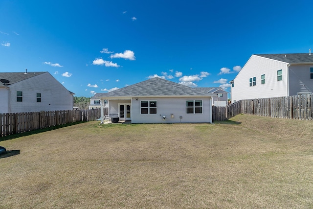 back of property featuring a yard, french doors, a fenced backyard, and roof with shingles