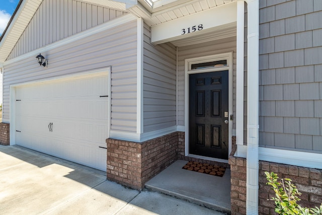 doorway to property featuring a garage and concrete driveway