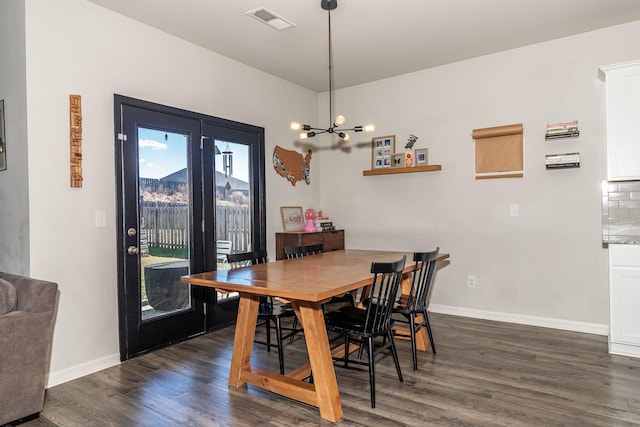 dining space featuring baseboards, dark wood-style floors, a chandelier, and visible vents
