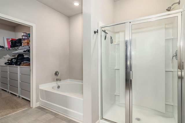 bathroom featuring tile patterned floors, recessed lighting, a spacious closet, a bath, and a stall shower
