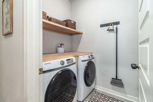 laundry room with laundry area, washer and clothes dryer, baseboards, and tile patterned flooring