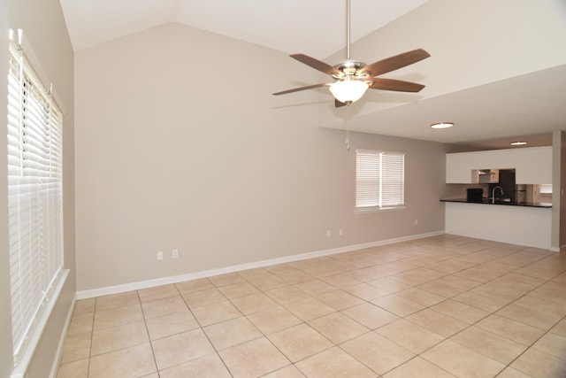 unfurnished living room featuring light tile patterned flooring, a sink, a ceiling fan, baseboards, and vaulted ceiling