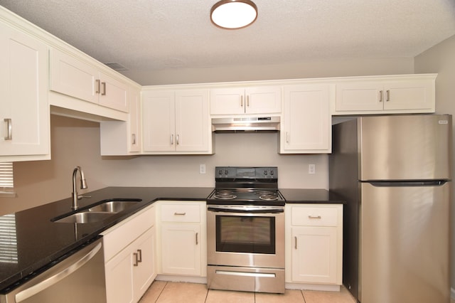 kitchen with appliances with stainless steel finishes, a sink, white cabinets, and under cabinet range hood