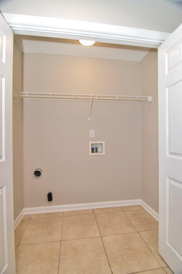 laundry area featuring light tile patterned floors, laundry area, hookup for a washing machine, and baseboards