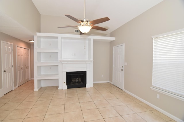 unfurnished living room with a fireplace, vaulted ceiling, baseboards, and light tile patterned floors