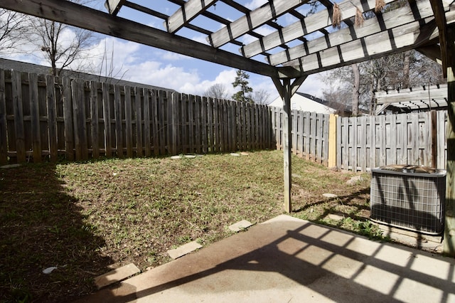 view of yard with a patio area, a fenced backyard, central AC, and a pergola