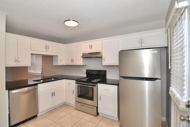 kitchen with stainless steel appliances, a sink, white cabinets, and under cabinet range hood