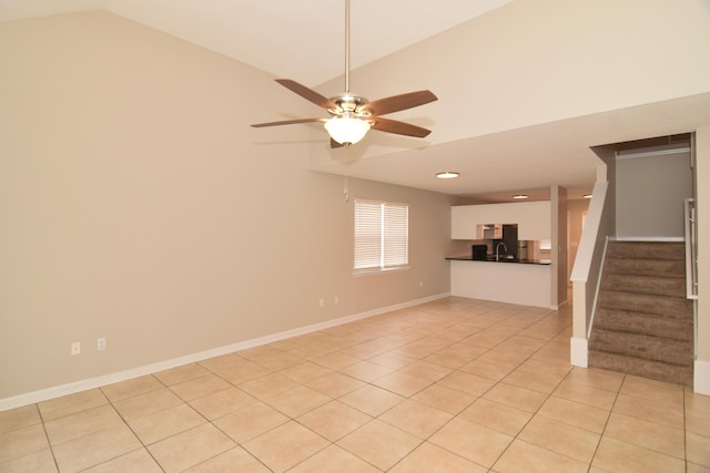 unfurnished living room featuring light tile patterned floors, lofted ceiling, a ceiling fan, baseboards, and stairs