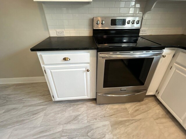 2210 Glendale Rd, Augusta, GA 30904 - kitchen with white cabinets, dark countertops, stainless steel electric stove, baseboards, and backsplash