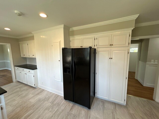 2210 Glendale Rd, Augusta, GA 30904 - kitchen with white cabinetry, ornamental molding, light wood finished floors, and black fridge