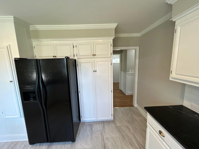 2210 Glendale Rd, Augusta, GA 30904 - kitchen with black refrigerator with ice dispenser, crown molding, and white cabinets