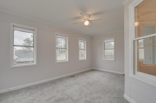 carpeted spare room with ceiling fan, baseboards, and ornamental molding