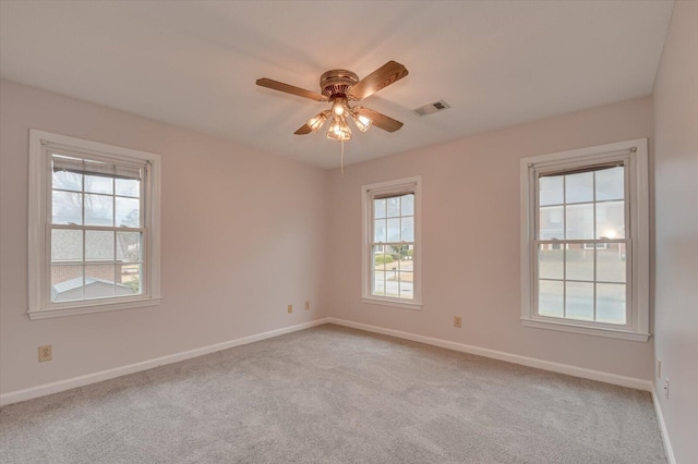 unfurnished room with visible vents, light colored carpet, and baseboards