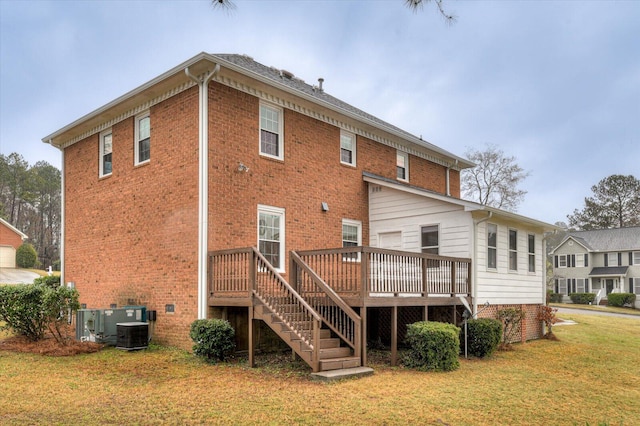 back of property with stairway, a yard, brick siding, and a wooden deck