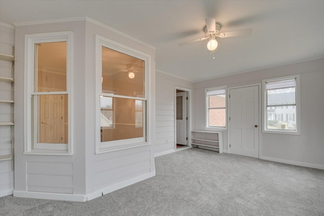 interior space with baseboards, ceiling fan, and ornamental molding