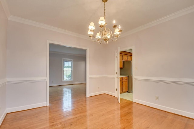 unfurnished room with a chandelier, baseboards, light wood finished floors, and ornamental molding