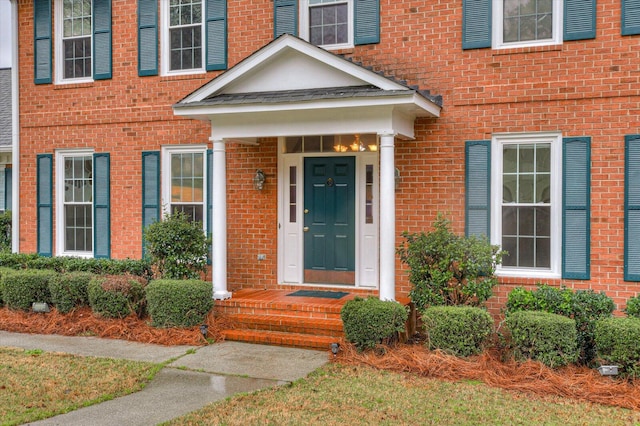 entrance to property featuring brick siding