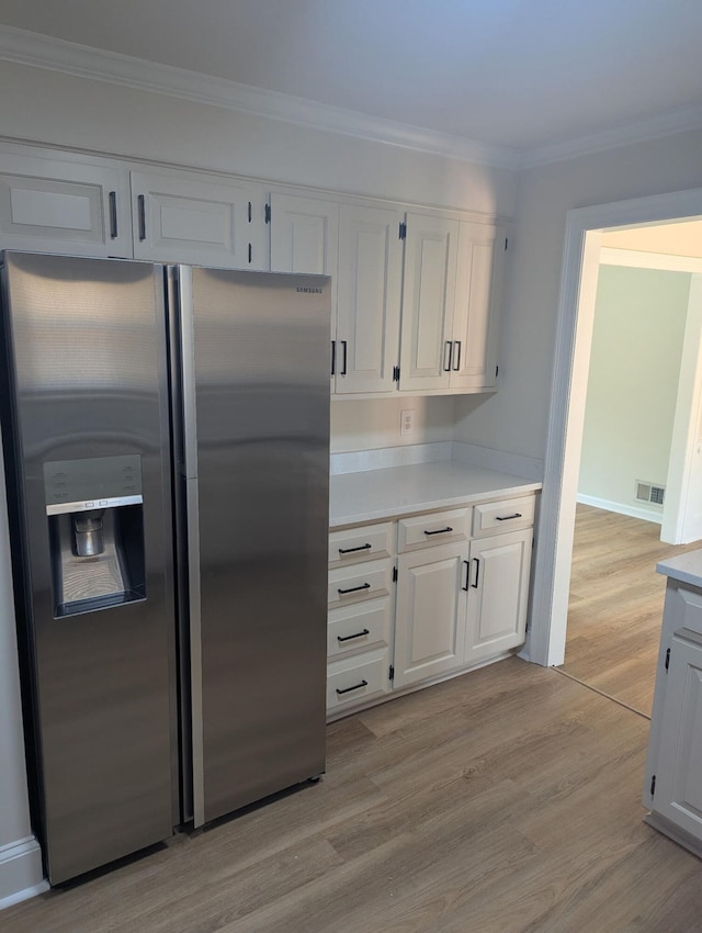 209 Biltmore Ct, Martinez, GA 30907 - kitchen with stainless steel refrigerator with ice dispenser, light countertops, light wood finished floors, white cabinets, and crown molding