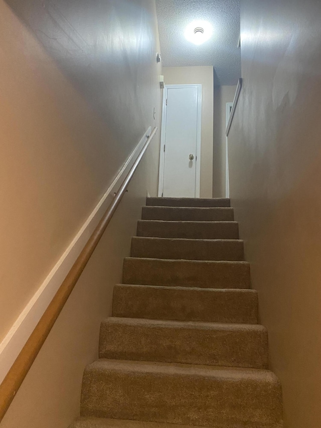 stairway with a textured ceiling