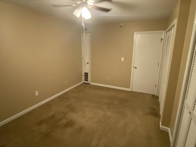 unfurnished bedroom with a textured ceiling, carpet floors, and ceiling fan