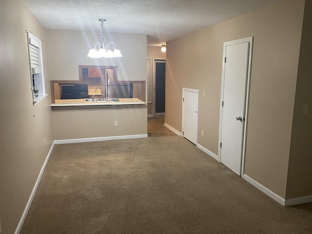 interior space with a textured ceiling, a notable chandelier, dark carpet, and sink