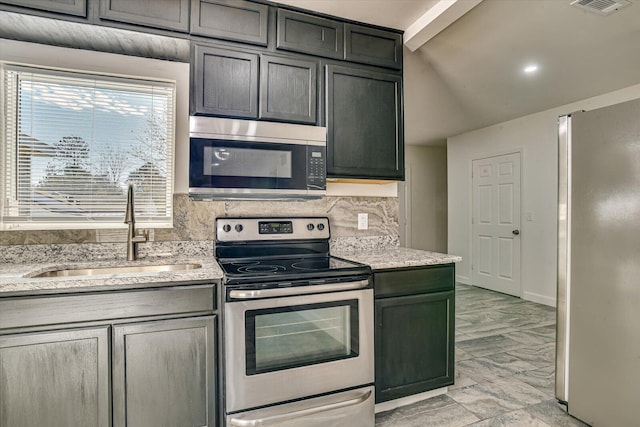 kitchen with light stone countertops, backsplash, stainless steel appliances, sink, and beam ceiling