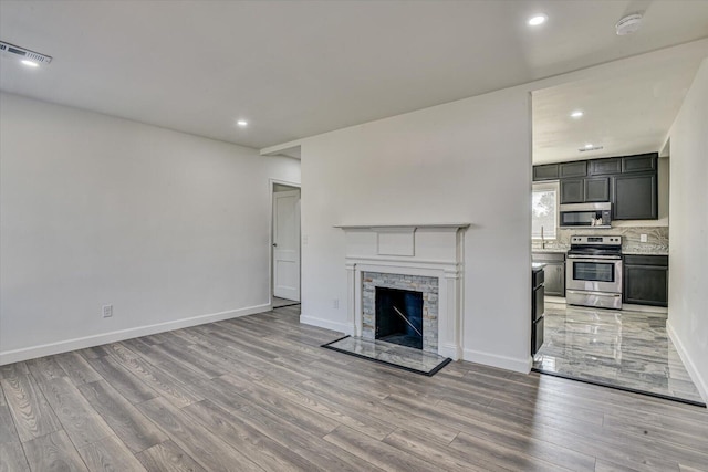 unfurnished living room with a fireplace and light hardwood / wood-style floors