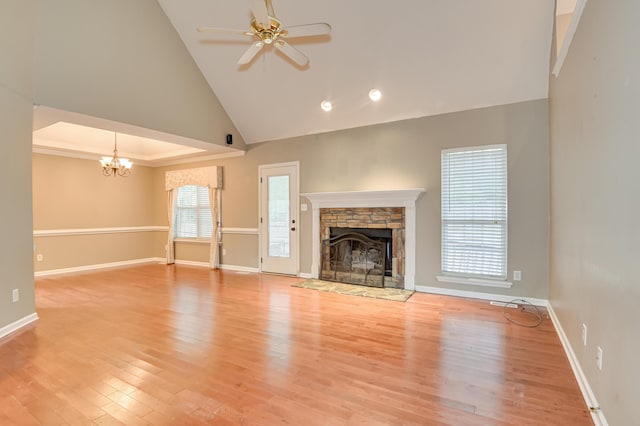 790 Osprey Ln, Martinez, GA 30907 - unfurnished living room with a chandelier, a stone fireplace, light wood finished floors, a ceiling fan, and baseboards