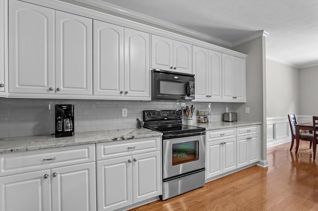 1109 Highmoor Ln, Evans, GA 30809 - kitchen featuring black microwave, electric range, ornamental molding, decorative backsplash, and white cabinets