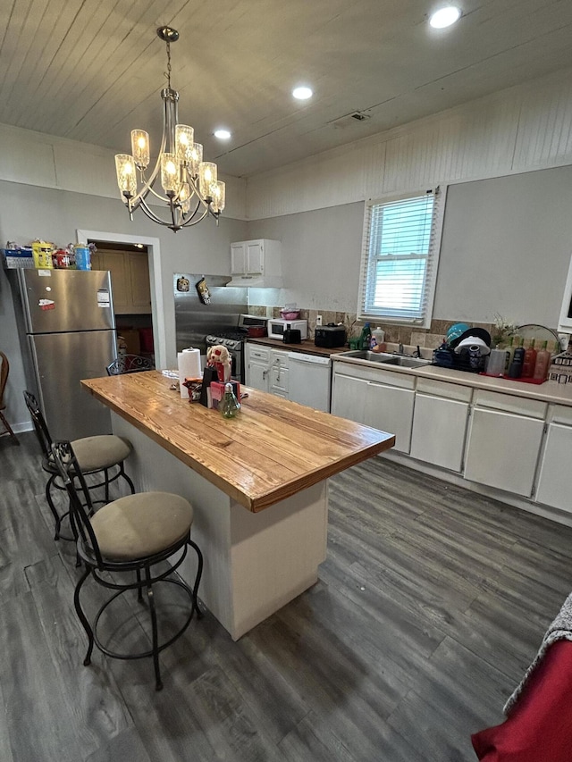 kitchen with a breakfast bar, butcher block counters, a kitchen island, white cabinetry, and appliances with stainless steel finishes