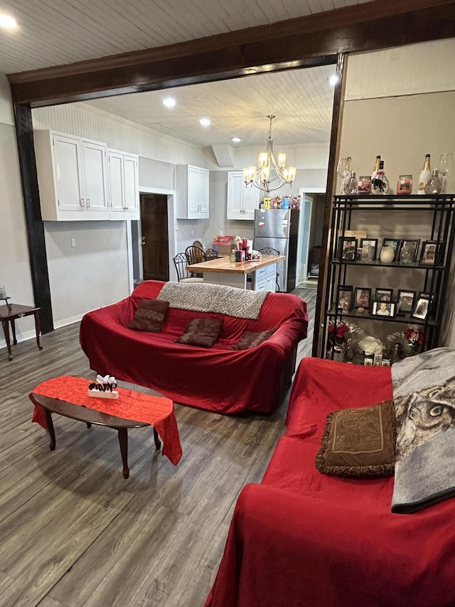 living room featuring dark wood finished floors, beamed ceiling, and an inviting chandelier