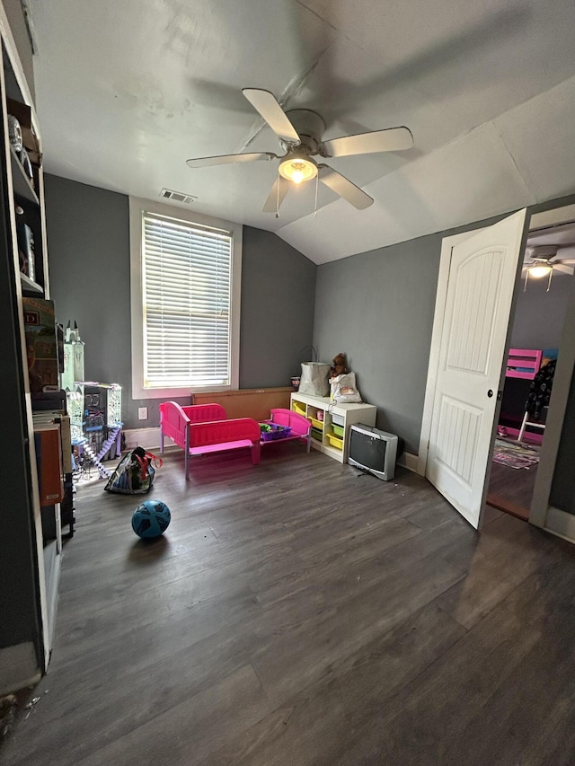 rec room with dark wood-style floors, lofted ceiling, visible vents, ceiling fan, and baseboards