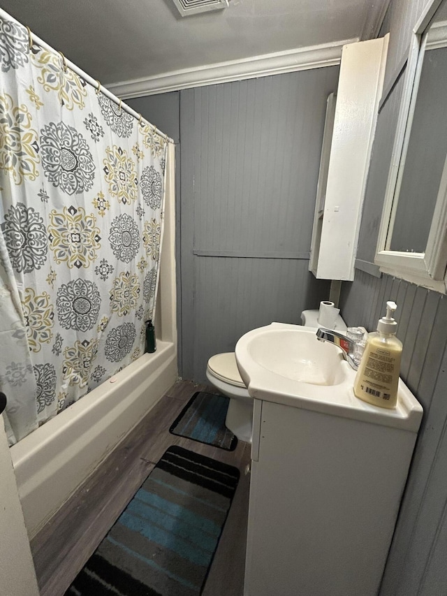 bathroom featuring shower / tub combo with curtain, vanity, toilet, and wood finished floors