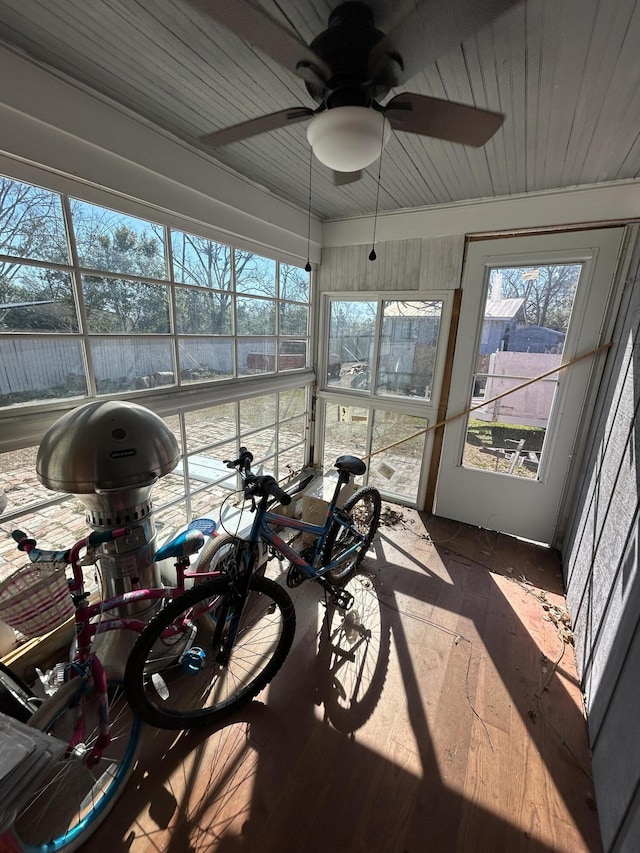 sunroom featuring wood ceiling, a wealth of natural light, and a ceiling fan